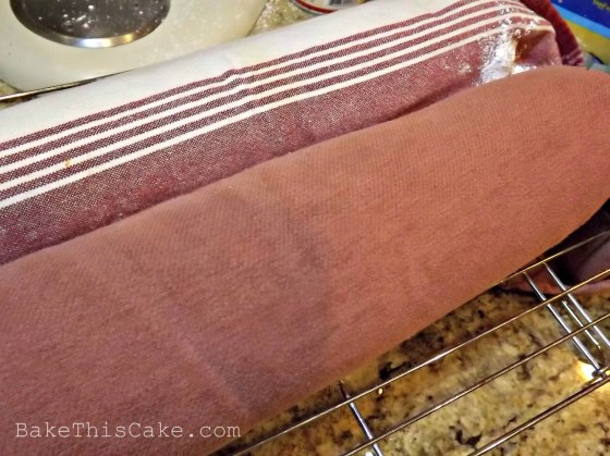 jelly roll cakes cooling in sugar dusted towels by Bake This Cake com